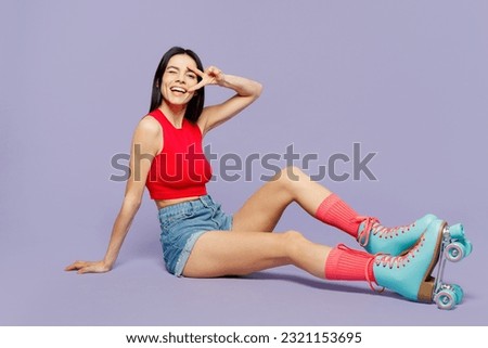 Full body happy smiling young latin woman she wear red casual clothes rollers rollerblading cover eye with victory gesture isolated on plain purple background. Summer sport lifestyle leisure concept