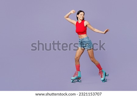 Full body smiling cheerful young latin woman she wear red casual clothes rollers rollerblading spread raise up hands isolated on plain pastel purple background. Summer sport lifestyle leisure concept