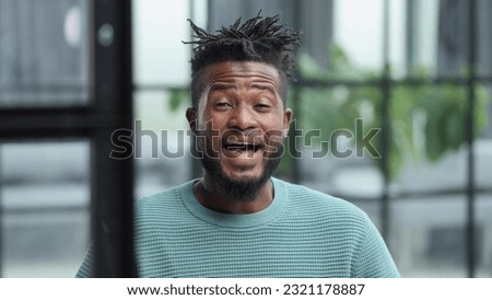 African American man in green sweater looking at camera