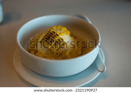 Grilled sweet corn and vanilla ice cream on white bowl, selective focus