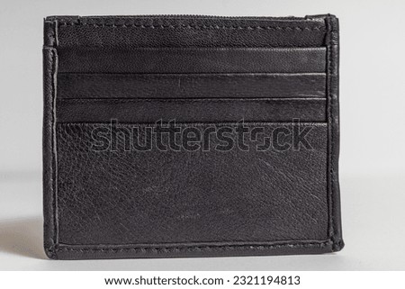 Black pure leather small pocket size card holder on white background.