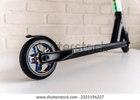 The rear wheel and brake of a Stunt scooter with rainbow-colored wheels. extreme skating in the skatepark and on the ramp. Details of the scooter. Repair and sale of extreme equipment Royalty-Free Stock Photo #2321196227