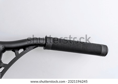 the handle bar of a stunt scooter with black rubber comfortable grips, a stunt scooter, equipment for extreme skating in a skatepark and on a ramp. Details of the scooter. Repair, rental and sale  Royalty-Free Stock Photo #2321196245