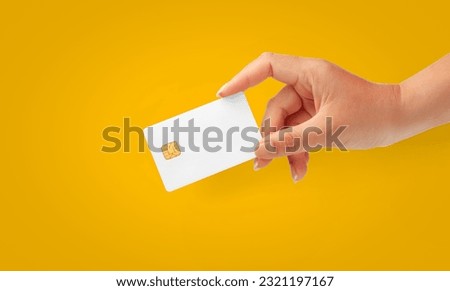 Woman Hand holding  blank credit chip card on a Yellow background for business and finance 
concept.