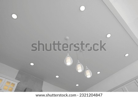 Ceiling with modern lamps in stylish kitchen, low angle view Royalty-Free Stock Photo #2321204847