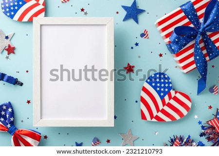 Labor Day festivities. Symbolic decorations top view: American flag-patterned hearts, shimmering stars, confetti, thematic giftbox on pastel blue surface with empty photo frame for messages or picture