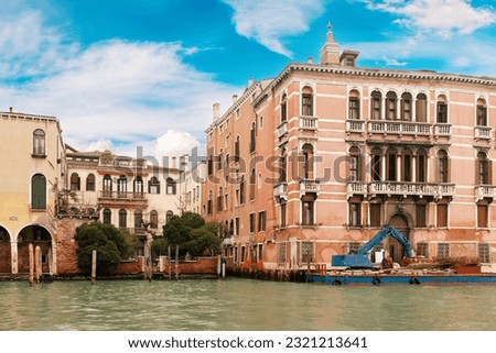 Canal with contruction boat near old buildings in Venice, Italy Royalty-Free Stock Photo #2321213641