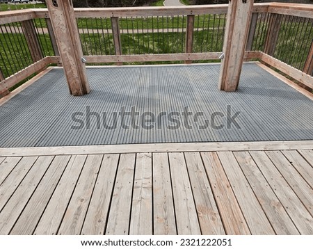 The base of two wooden poles with showers on them in a shower area outside at a beach.