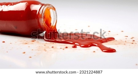 A bottle with ketchup has spilled on the white background. Royalty-Free Stock Photo #2321224887