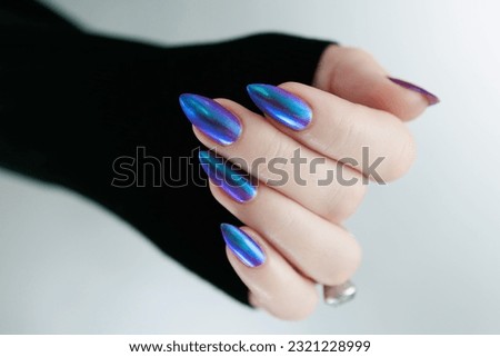 beautiful female hand with long nails, purple and blue manicure 
