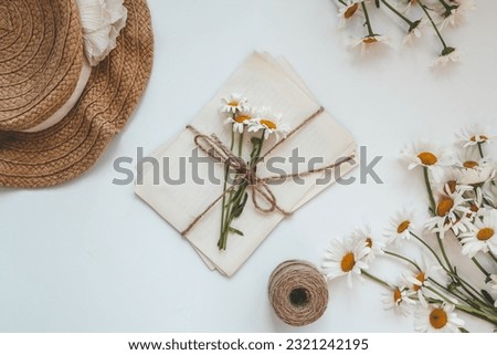 Letters in vintage style, daisies and a hat, summer flat lay. Royalty-Free Stock Photo #2321242195