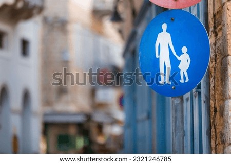 A street sign of a man and a child holding hands