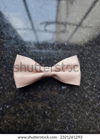Bow hair clip for cute girls on a black grainy background.