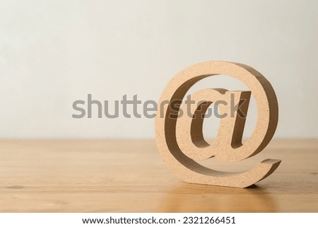 Wooden email address sign symbol on wooden table with white wall background copy space. Concept of customer service, support and communication in business.
