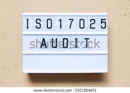 Lightbox with word ISO 17025 audit on wood background