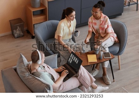 High angle portrait of young women using devices in meeting and working on IT project together Royalty-Free Stock Photo #2321293253