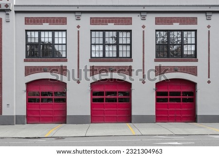 3 red garage doors at a modern fire station in downtown Seattle with red brick highlights Royalty-Free Stock Photo #2321304963