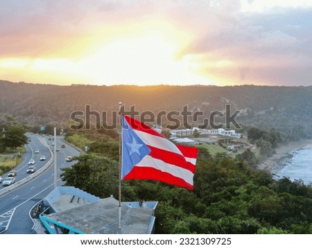 An aerial closeup shot of the Flag of Puerto Rico waving in the air at sunset
