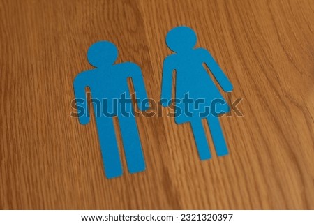 A man and woman sign icon on a wooden background