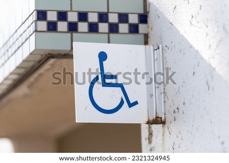 A close-up shot of disabled person's restroom sign on an old metallic banner