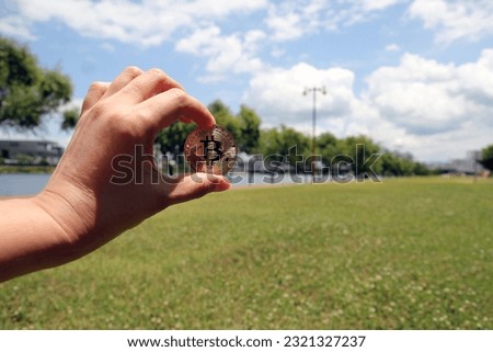 Bitcoin gold coin, Hand hold bitcoin in the park and natural background