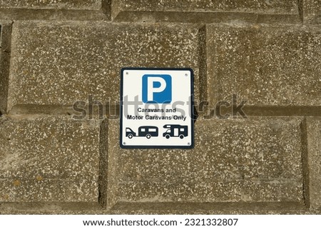 A caravans and motor caravans parking sign on a brick wall background.
