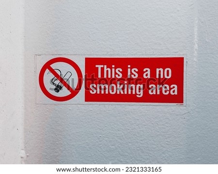 A red sign on the doors about limitations against smoking
