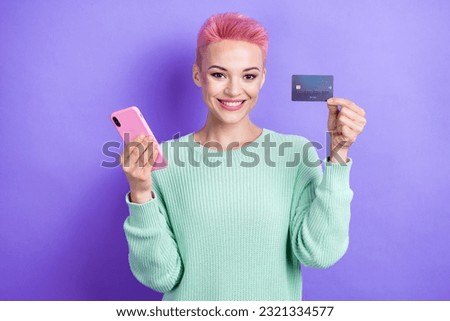 Photo of attractive person hold smart phone plastic debit card toothy smile isolated on violet color background