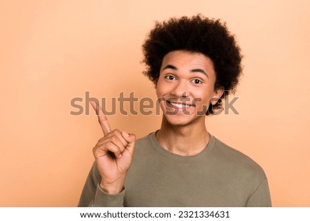 Photo of nice positive young person beaming smile indicate finger empty space novelty isolated on beige color background