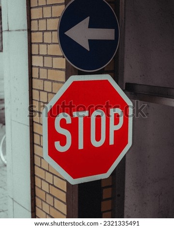 A vertical closeup shot of a Stop sign and one-way sign put on a building on the street