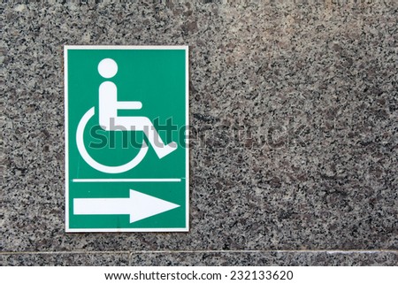 Label sign of person with a disability on marble wall.