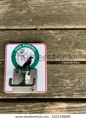 A metal dog parking hook for tying the dog with a rope and leaving your hands free, on a wooden background