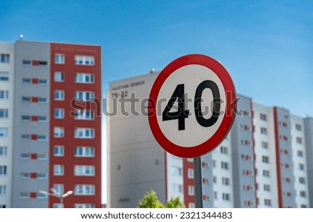 A closeup shot of traffic sign 40 speed limit in background of buildings