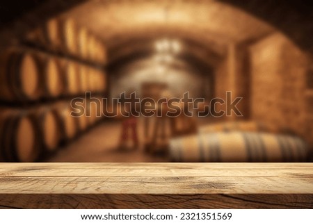 Empty wooden table. Blurred wine cellar in the background. Winery and beverage concept