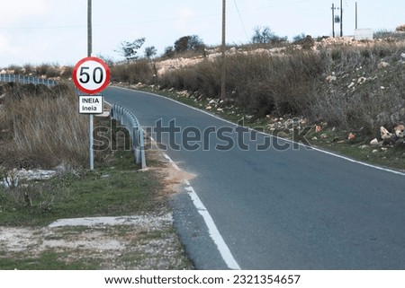 A paved road with a road sign prohibiting the movement of vehicles and motorcycles