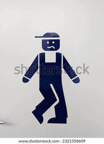 A vertical funny bathroom sign with blue male icon holding his pee