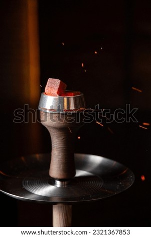 Coals for hookah close-up. Burning coals on the hookah bowl with copy space. Arabian style tourism. hookah bar concept
 