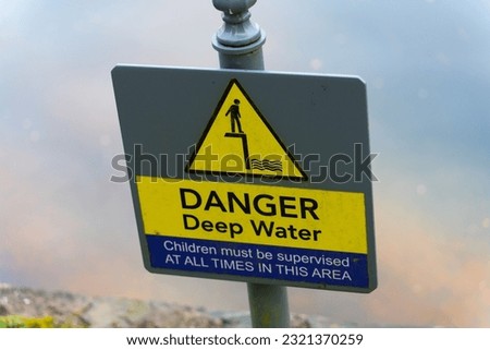 A closeup shot of a "Danger Deep Water" phrase on a sign