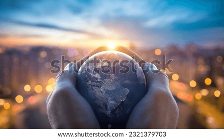 Planet Earth in the hands of a man against the background of the lights of the evening city. Concept and symbol on the theme of ecology, earth conservation. Elements of this image furnished by NASA. Royalty-Free Stock Photo #2321379703