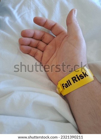A closeup shot of a patient in hospital wearing a yellow armband to indicate a fall risk