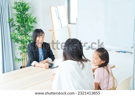 Conversation scene of a woman in a suit with a parent and child Royalty-Free Stock Photo #2321413855