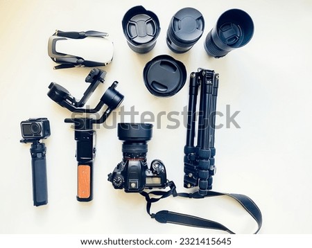 Flat lay composition with equipment for professional photographer on white table background. Gimbal, lens, drone, tripod, camera, action camera outdated. Isolated Space for text