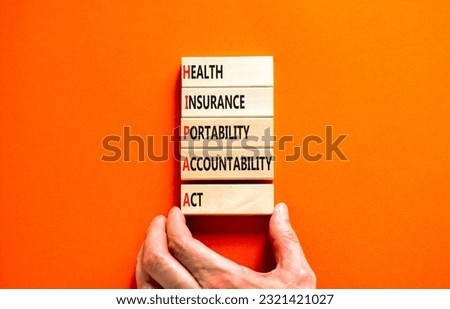 HIPAA symbol. Concept words HIPAA health insurance portability accountability act on wooden block. Beautiful orange background. Business HIPAA health insurance portability accountability act concept.