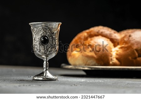 Shabbat Shalom challah bread, shabbat wine on a dark background, place for text, top view, Royalty-Free Stock Photo #2321447667