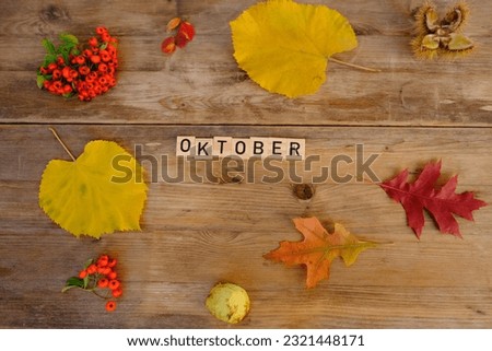 Autumn composition on rustic wooden table in garden with fallen yellow, orange leaves and berries, concept happy Thanksgiving, outdoor tea party, good weather, cozy autumn mood