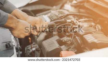 Automobile mechanic repairman hands repairing a car engine automotive workshop with a wrench, car service and maintenance,Repair service. Royalty-Free Stock Photo #2321472703