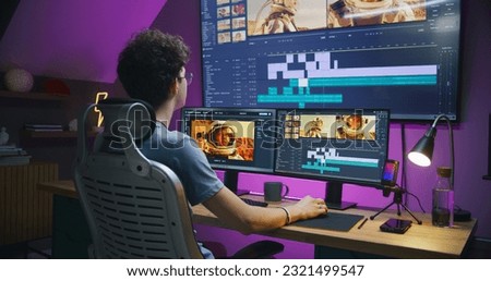 Young editor works at home office, edits sound tracks for video or movie about space mission. Film footage and software interface with tools on PC and big digital screen. Concept of post production.