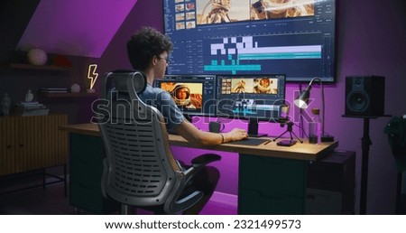 Young editor, video maker edits sound tracks for movie with astronauts, works at home office. Film footage and program interface with tools on computer and big digital screen. Post production concept.