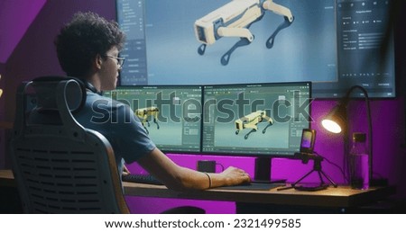 Young 3D designer creates robot 3D visualization and prototype, works on project at home on computer and big digital screen with professional program interface and tools for 3D modeling and design. Royalty-Free Stock Photo #2321499585