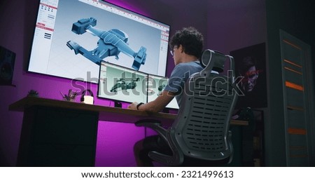 Teenage designer creates aircraft 3D visualization and prototype, works on 3D modeling project at home on computer and big digital screen with professional software interface and tools for design. Royalty-Free Stock Photo #2321499613